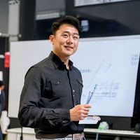 数据建模专家王浩然，休闲装站立于白板前，手持马克笔讲解足球数据模型，学术氛围